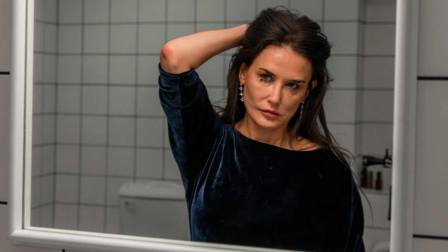 Demi Moore dans The Substance, se regardant devant le miroir.
