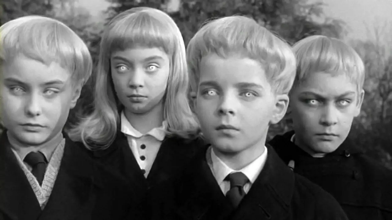 Image en noire et blanc, issue du film le village des damnés, on y voit 4 enfants en gros plan, tous identiques et avec un lueur maléfique dans les yeux.