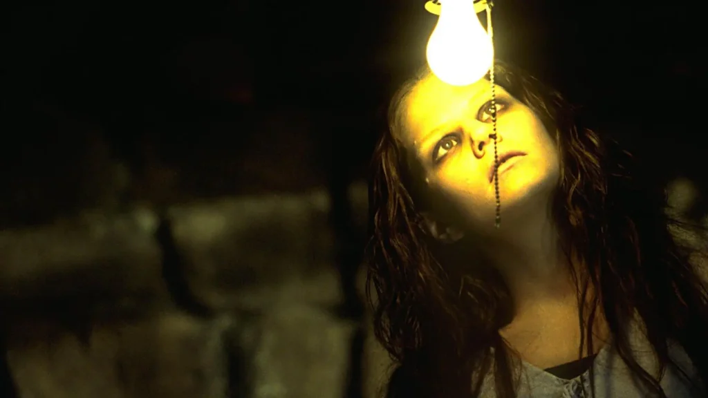Une femme sans un genre de sous-sol semble fascinée par la lumière d'une ampoule.