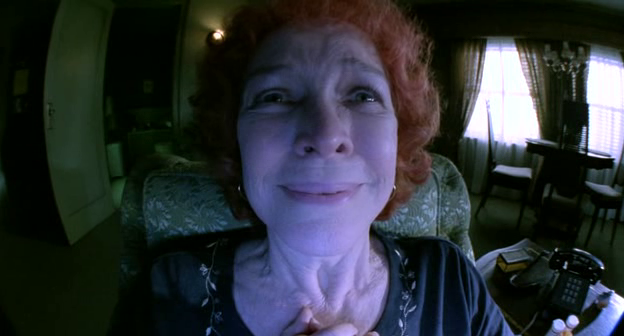 Une une femme en gros plan fisheye qui semple sur le point de craquer. Scène tirée de Requiem for a dream.