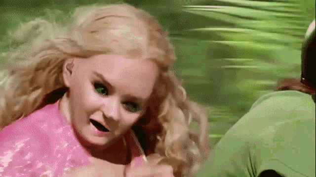 Une femme au visage déformé derrière un scooter. Image tirée du film Scooby-Doo