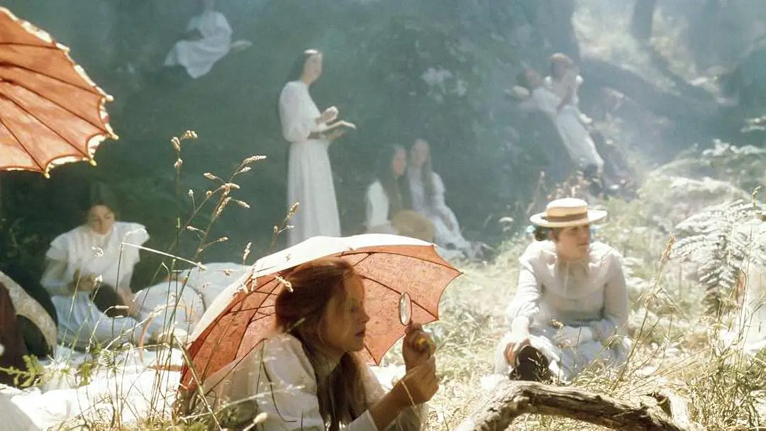 Des jeunes filles à l'aube du XXe siècle, habillée en robe blanche s'énuient dans la nature.