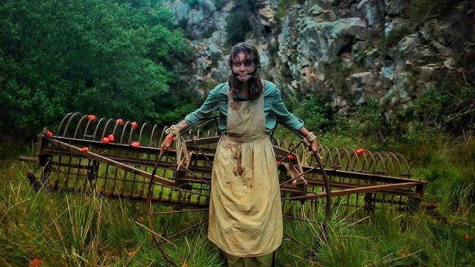 Une femme attaché à un enfin agricole et recevant des pommes de la part d'autres villageois. Image tirée du film The Severed Sun.