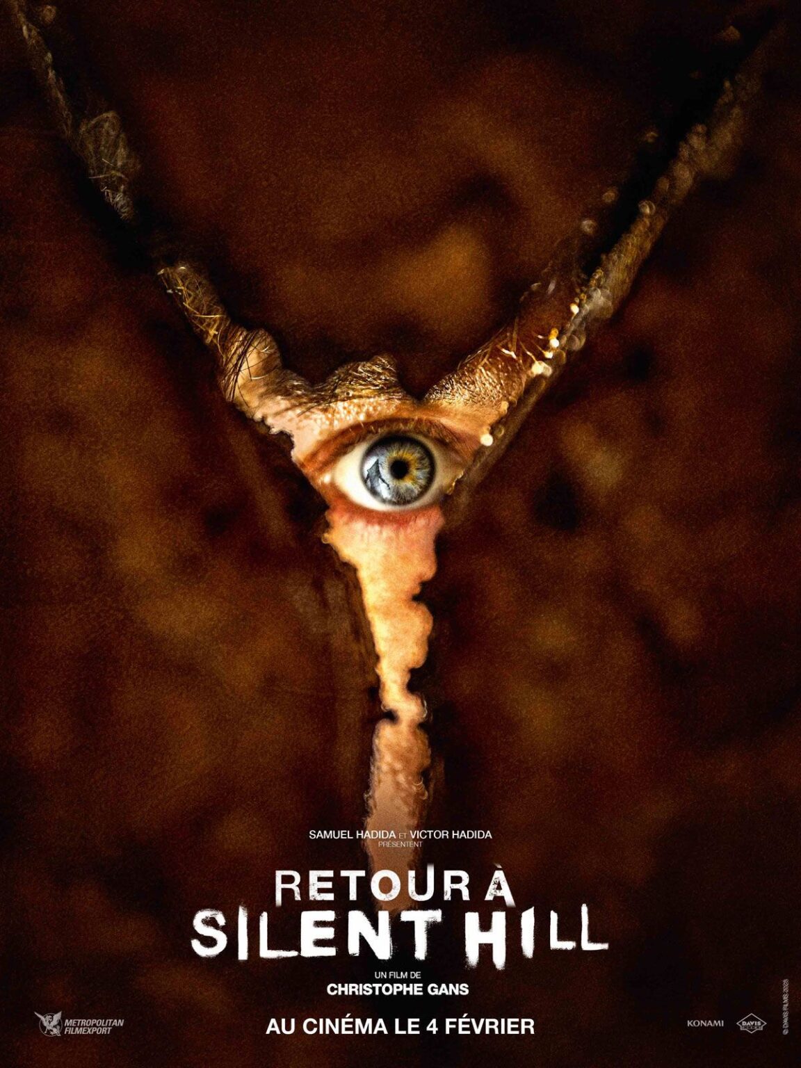 Affiche officiel du film Retour à Silent Hill (2026). On y voit un œil regardé à travers la fente d'un mur.