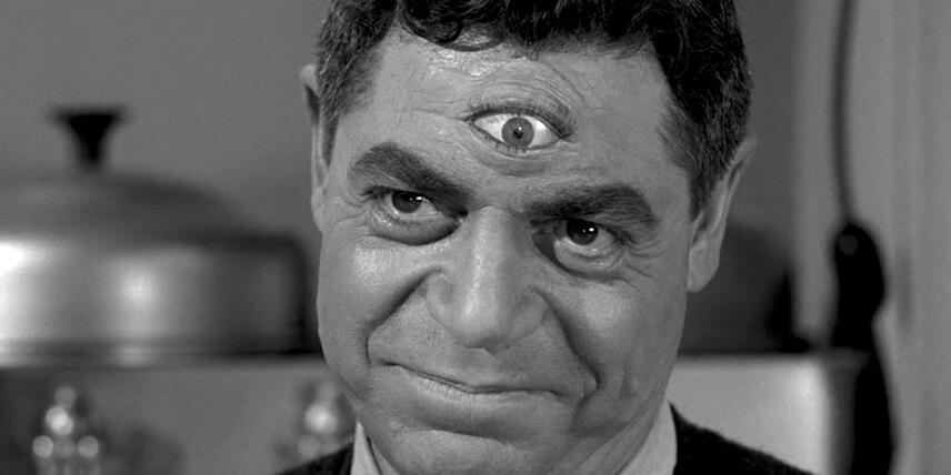 Un homme avec un troisième œil sur le front souri. Image tirée de la série The Twilight Zone.