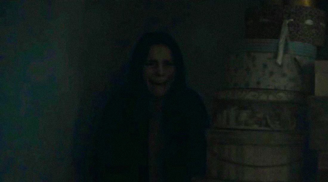 Un visage effrayant d'une femme possédé, dissimulé dans la pénombre. L'image est tirée du film Obsession (2026)