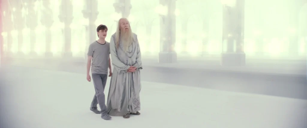 Un jeune homme marche à côté d'un vieillard dans une gare toute blanche et vide. Image tirée de Harry Potter et les reliques de la mort.